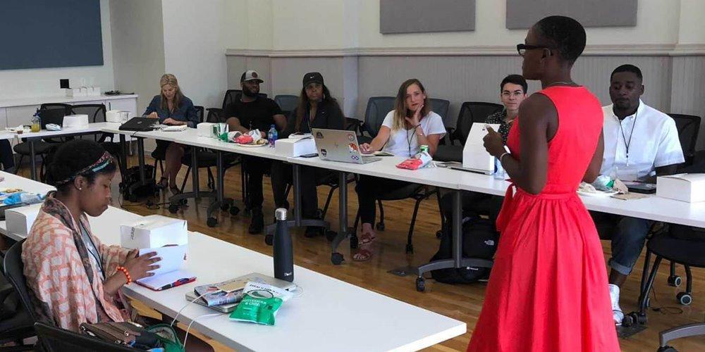 Woman in red dress stands in front of classroom