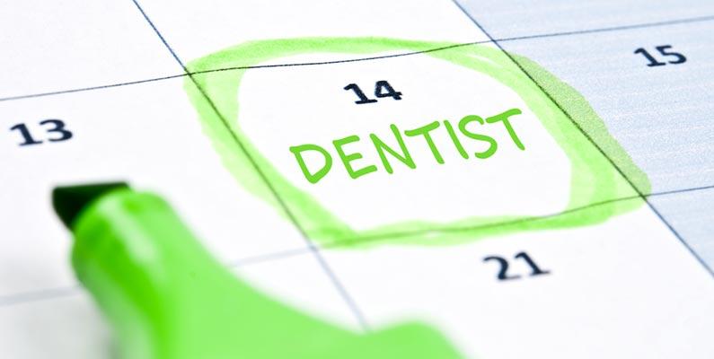 A close up of a calendar with the word dentist circled on the 14th day