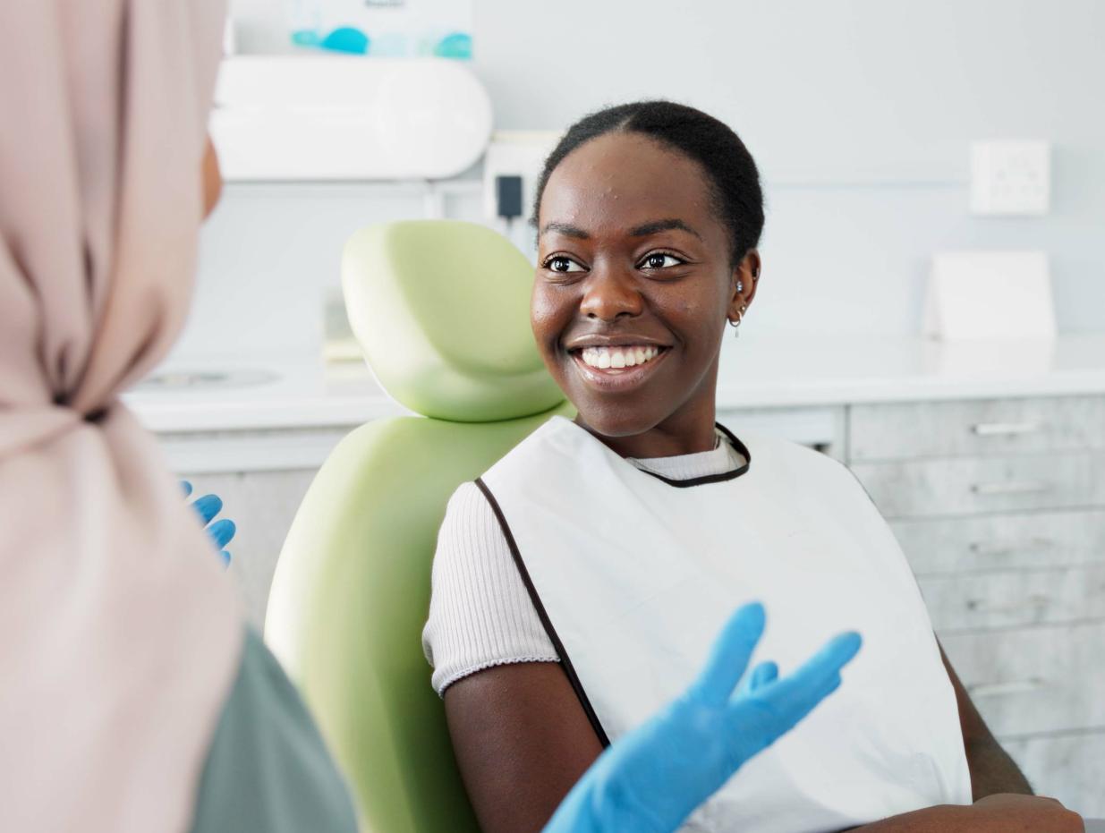 A person sitting in an exam chair at a dentist appointment