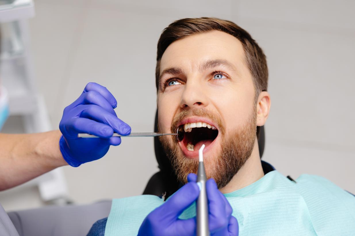 Patient in a dentist chair smiling having teeth looked at