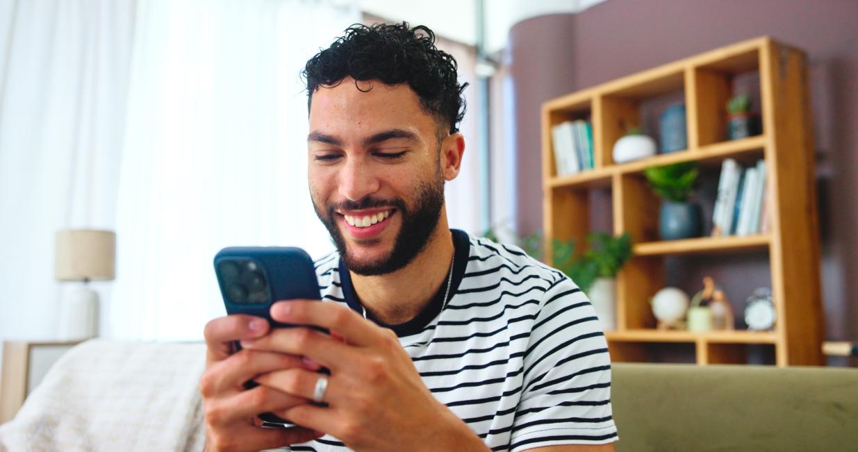 a man holding his phone and smiling