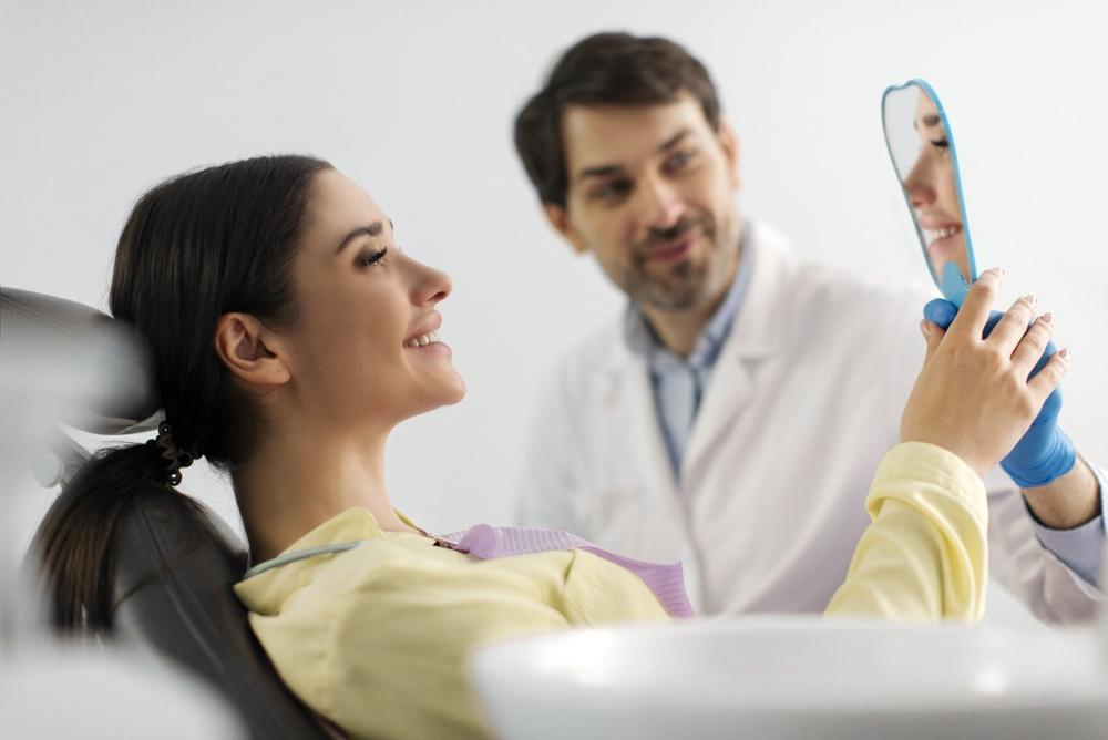 Woman looking in mirror at dentist