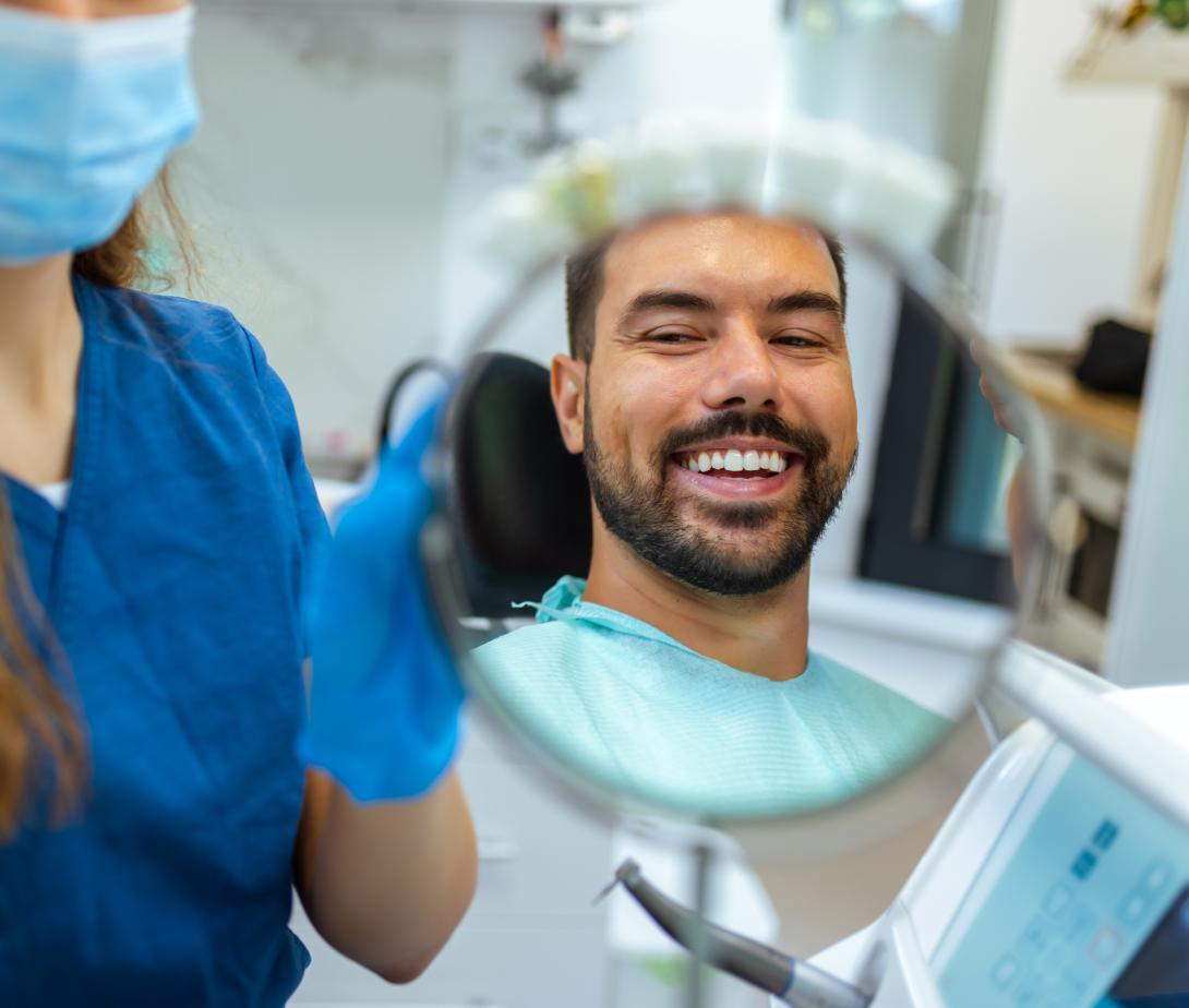Man looking in mirror at dentist